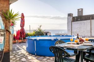 a hot tub on a patio with a table and chairs at Casa da Legua -Panoramic Ocean View w Terrace in Pataias