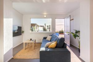 a living room with a blue couch and a table at Casa da Legua -Panoramic Ocean View w Terrace in Pataias