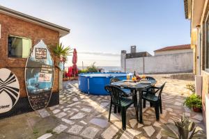 a patio with a table and chairs on a patio at Casa da Legua -Panoramic Ocean View w Terrace in Pataias