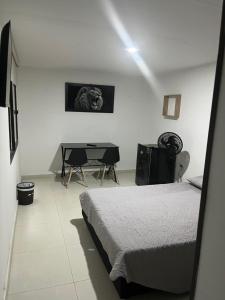 une chambre avec un lit et une table dedans dans l'établissement Primavera house - Habitaciones Full amobladas, à Ibagué