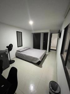 une chambre avec un lit et une chaise dedans dans l'établissement Primavera house - Habitaciones Full amobladas, à Ibagué