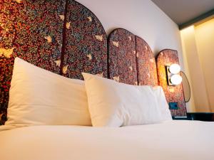 a bedroom with a bed with a large headboard at Ibis Styles Madrid Centro Maravillas in Madrid