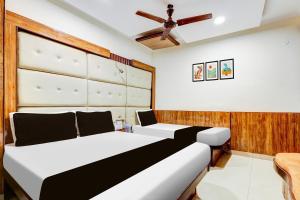 a bedroom with two beds and a ceiling fan at HOTEL O VIN INN in New Delhi