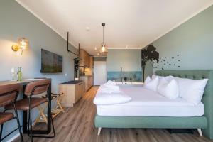 a bedroom with a bed and a table and a kitchen at WEIDE SUITES Stubaital - Adults Only in Schönberg im Stubaital