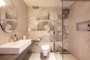 a bathroom with a sink and a toilet and a shower at WEIDE SUITES Stubaital - Adults Only in Schönberg im Stubaital +24 photos