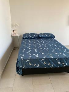 a bed with a blue comforter and pillows on it at Monoambiente a estrenar con BALCÓN y DECK in La Plata