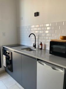a kitchen with a sink and a microwave at Monoambiente a estrenar con BALCÓN y DECK in La Plata