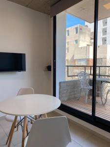 a room with a table and chairs and a balcony at Monoambiente a estrenar con BALCÓN y DECK in La Plata