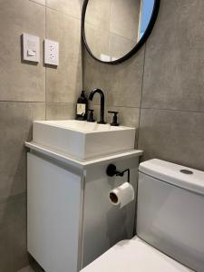 a bathroom with a sink and a toilet and a mirror at Monoambiente a estrenar con BALCÓN y DECK in La Plata +12 photos