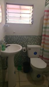 a bathroom with a sink and a toilet and a window at Ana's Place in Santa Ana