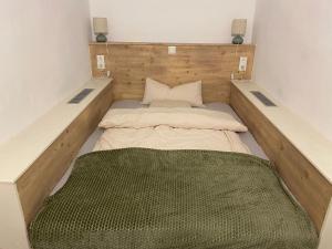 a small room with two beds and a green blanket at Biohof Kroisleitner Ferienwohnung Abendsonne 