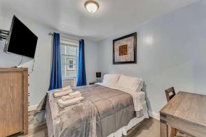 Un dormitorio con una cama y un televisor de pantalla plana. en Shortstop Apt 1 All Star Baseball Rentals, en Oneonta