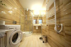 a bathroom with a washing machine and a sink at Rezydencja Park Rodzinna - FAF in Mielno +19 photos