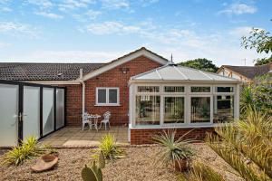 a conservatory with a table and chairs on a patio at The Palms in Brundall