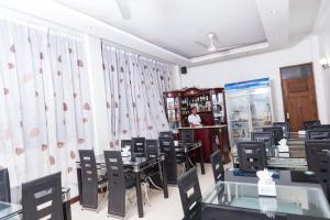 a room with tables and chairs and a woman in a store at Hotel de Mag Deluxe in Dar es Salaam +32 photos