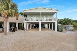 a large house with a porch and a balcony at Navigate Stays Private Home with Pool Hot-Tub & Dock in Crawl Key Number Two