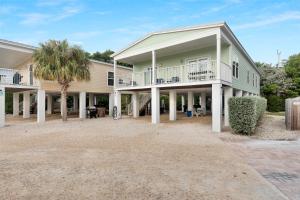 a large house with a palm tree in front of it at Navigate Stays Private Home with Pool Hot-Tub & Dock in Crawl Key Number Two