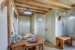 una sala da pranzo con tavolo e sedie in legno di The Hayloft at Ryes Farm a Crowfield