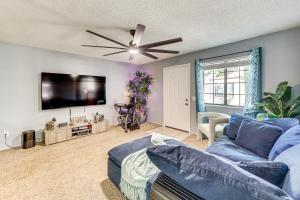 Una sala de estar con un sofá azul y un televisor de pantalla plana. en Ground-Level Getaway 3 Mi to Bullhead City Parks, en Bullhead City