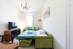 a living room with a table and a green couch at Marina - appartamento in centro al mare Ostia in Lido di Ostia