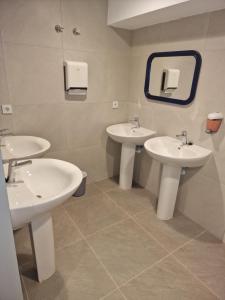 a bathroom with two sinks and a mirror at Albergue Cafetería La Parada in Villarquemado +6 photos
