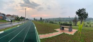 eine Bank am Straßenrand neben einer Straße in der Unterkunft Verdant Treehouse in Kigali