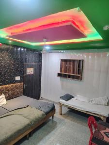 two beds in a room with a colorful ceiling at Shri laddu Gopal dham in Chhatikara