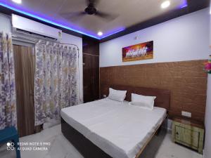a bedroom with a white bed with a curtain at Shri laddu Gopal dham in Chhatikara +13 photos