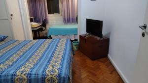 ein Hotelzimmer mit einem Bett und einem Fernseher in der Unterkunft Brazil Cozy and Comfortable in Rio de Janeiro