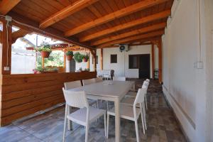 a patio with a white table and chairs at Casa Selina in Corbu