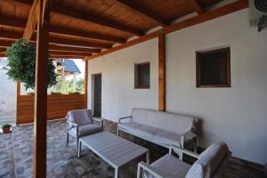 a porch with a bench and a table and chairs at Casa Selina in Corbu