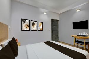 Un dormitorio con una cama, un escritorio y un televisor. en Collection O Singha Crossway Formerly Hotel Star Key, en Gurgaon