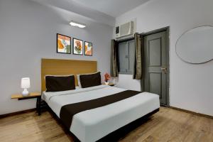 Un dormitorio con una gran cama blanca en una habitación. en Collection O Singha Crossway Formerly Hotel Star Key, en Gurgaon