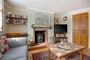 un soggiorno con tavolo e camino di Owl Cottage a Holt