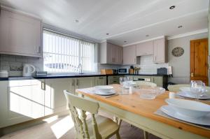 una cucina con tavolo in legno e piatti bianchi di Owl Cottage a Holt