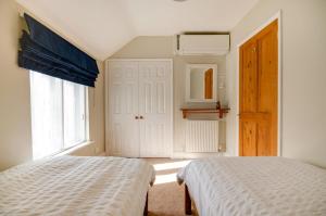 una camera da letto con un letto, una finestra e una porta di Owl Cottage a Holt