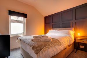 a bedroom with a bed with two towels on it at Station House in Redcar