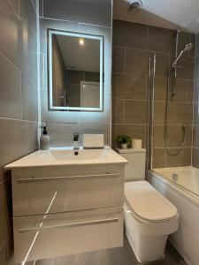a bathroom with a sink and a toilet and a shower at Spotless Two-Bedroom Home with Garden and Parking in Stevenage +21 photos
