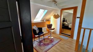 a living room with a chair and a bedroom at hostinec Thérése in Petrovice