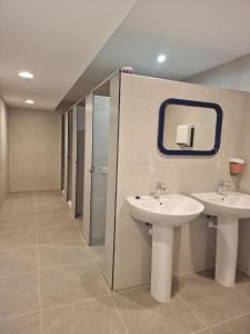 a bathroom with two sinks and a mirror at Albergue Cafetería La Parada in Villarquemado +11 photos
