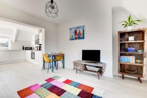 a living room with a table and a television at Jessie’s - Ellinbrook Apartments in Hunstanton