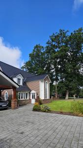 a house with a driveway in front of it at Ferienwohnung Drei Eichen in Wurster Nordseeküste