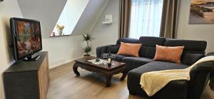 a living room with a couch and a coffee table at Ferienwohnung Drei Eichen in Wurster Nordseeküste