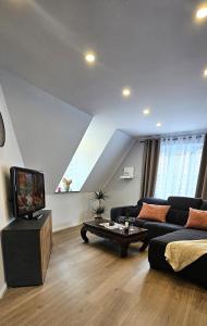 a living room with a couch and a tv at Ferienwohnung Drei Eichen in Wurster Nordseeküste +8 photos