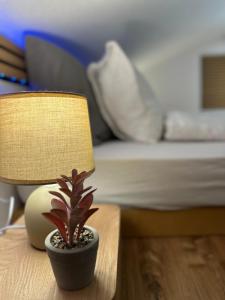 a lamp and a plant on a table next to a bed at Mountaindreams, Wallis, near Saas-Fee, SKi, near Mattmark in Saas-Almagell