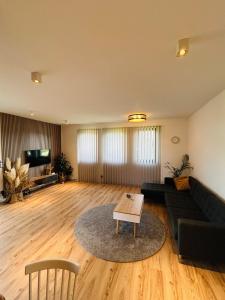 a living room with a black couch and a table at Luxury 2 bedroom apartment and garden in Strzyżewo Witkowskie