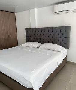 a bedroom with a large bed with white sheets at 303 Espectacular Apartamento en granada in Cali
