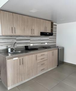 a kitchen with wooden cabinets and a sink at 303 Espectacular Apartamento en granada in Cali