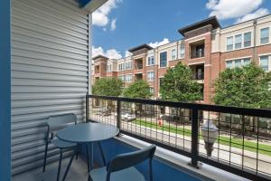un balcone con tavolo e sedie e un edificio di Queen Downtown Views Riverfront Stay Free Parking a Fort Worth