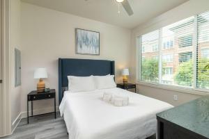 una camera da letto con un grande letto bianco con due lampade di Queen Downtown Views Riverfront Stay Free Parking a Fort Worth